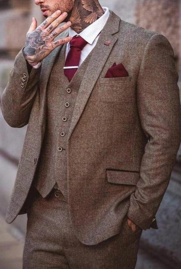 a brown wool herringbone tweed three piece vintage style suit with a white shirt and red tie.