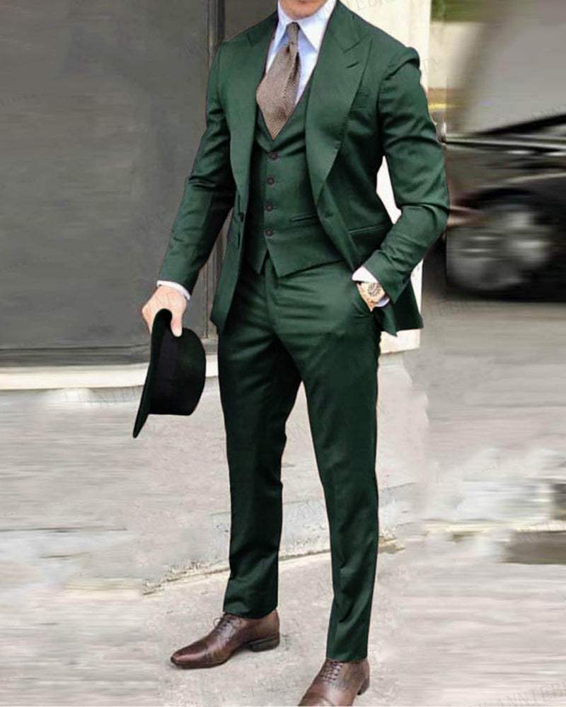 dark green three-piece suit with a blazer, trousers, and a tie, holding a hat